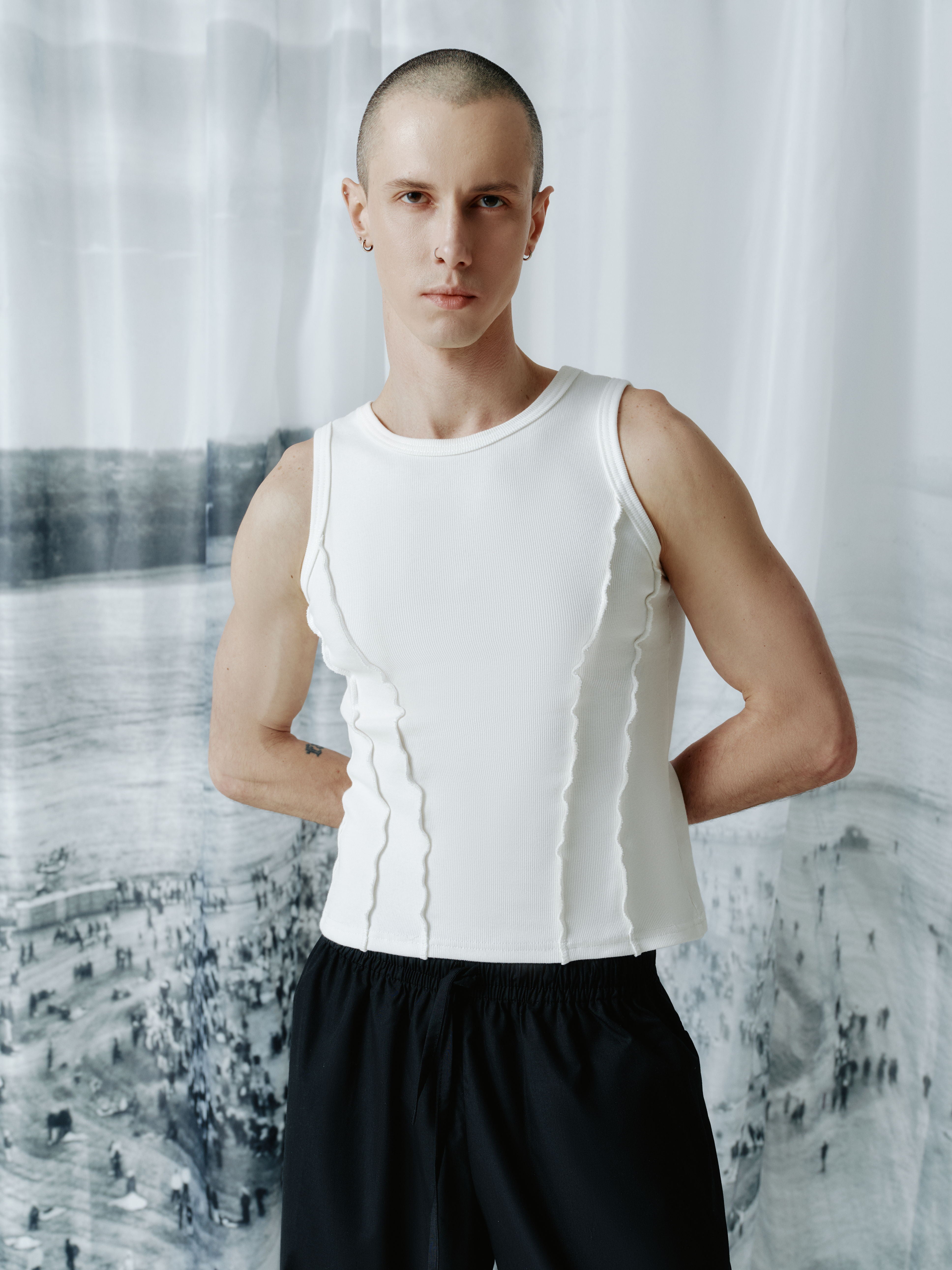 Male model wearing the ribbed tank top from the back, showcasing the smooth design and modern, clean lines of the piece