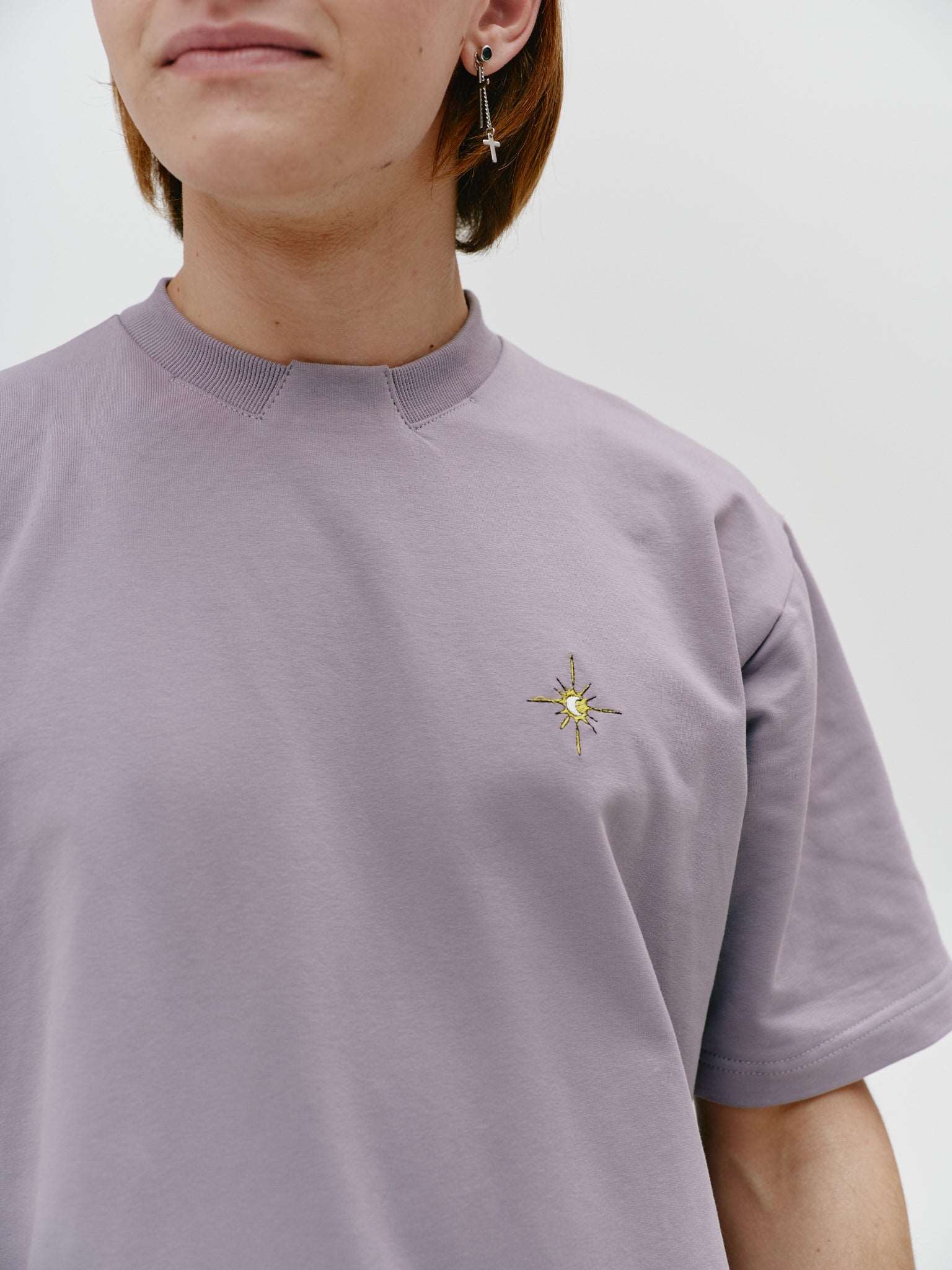 Close-up view of a dark grey unisex cotton t-shirt, highlighting the stand-up collar and intricate embroidery, adding a refined touch to the casual design