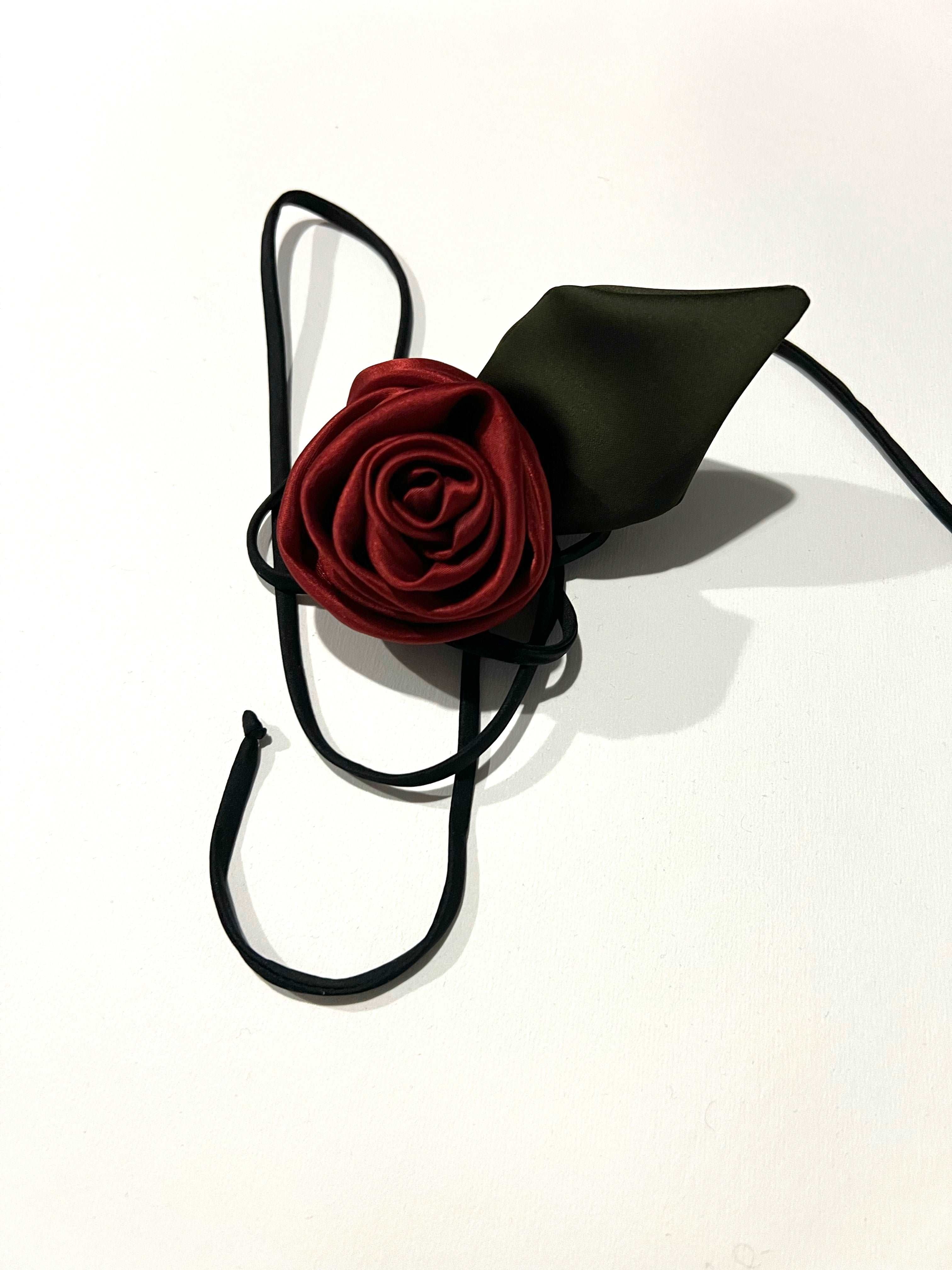 Close-up view of the silk hair elastic featuring delicate rose embellishments, capturing the symbolic beauty and craftsmanship