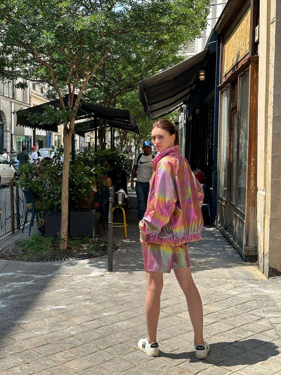 Back view of the model in holographic sport-style shorts, displaying the stylish cut and eye-catching shimmering effect