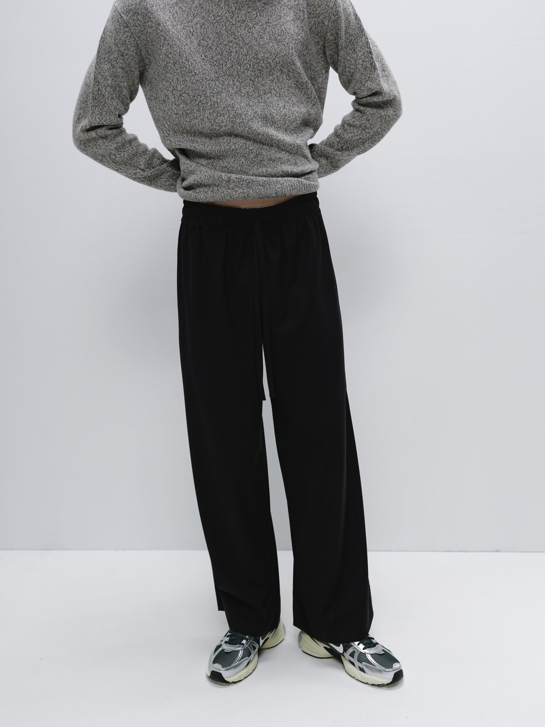 Model standing in wide-leg pants made from suiting fabric, demonstrating the relaxed yet sophisticated fit and breathable design