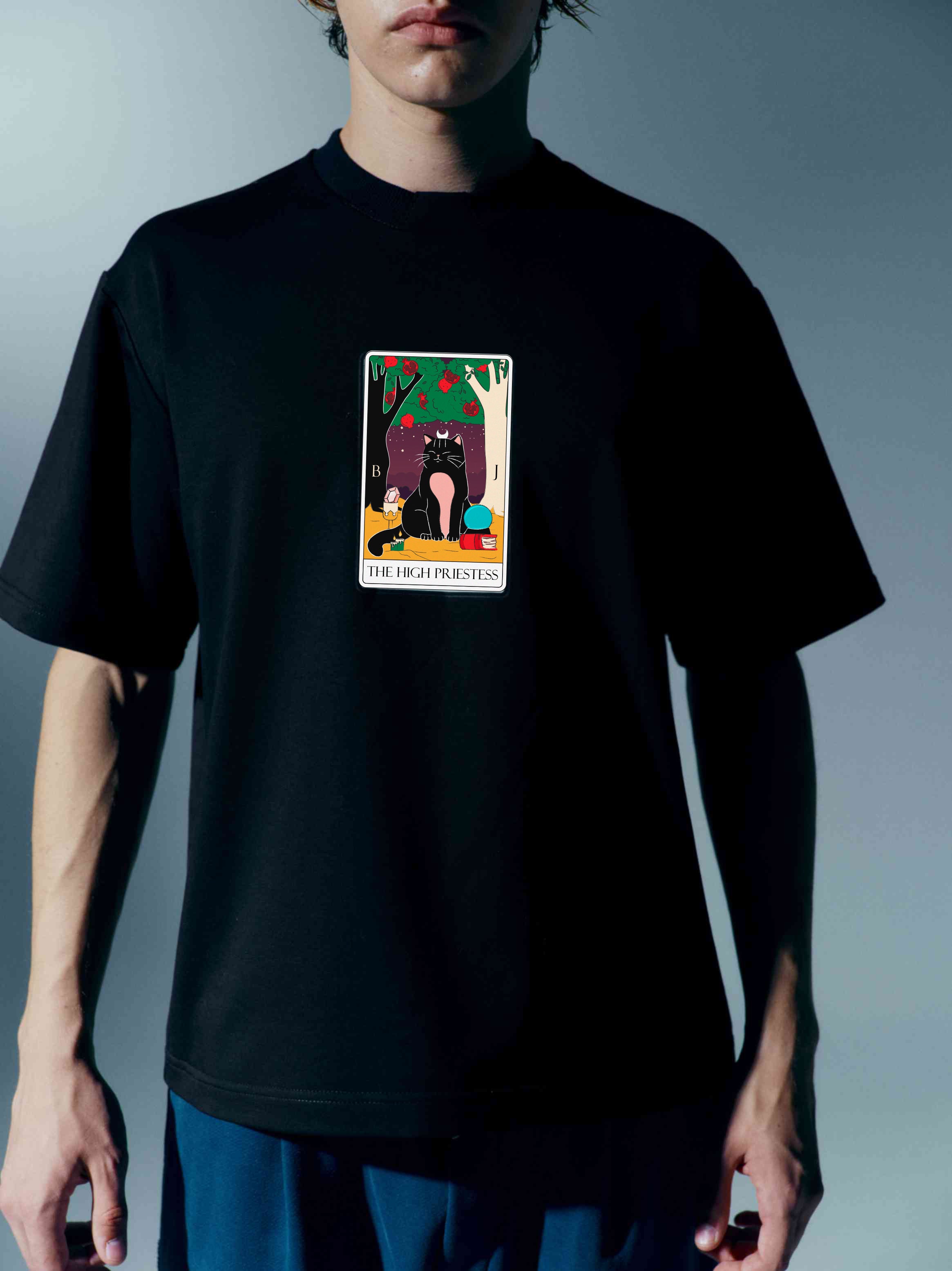 Detailed shot of a unisex cotton t-shirt with a bold Tarot card print, inspired by moon imagery, showcasing the mystical allure and modern design with a stand-up collar