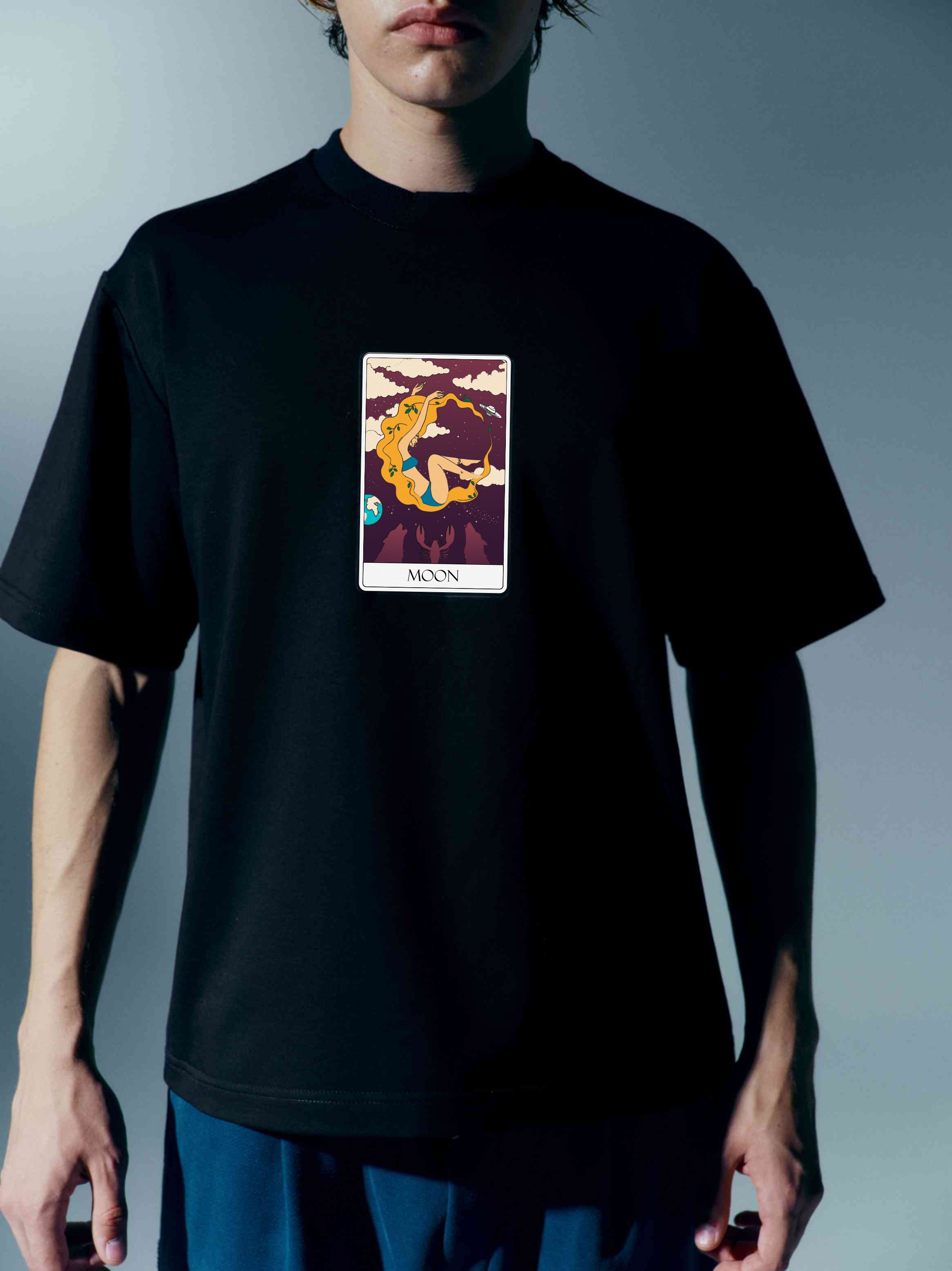 Front view of a unisex cotton t-shirt adorned with a Tarot card print, part of 'The Moon' collection, offering a unique blend of fashion and arcane symbolism
