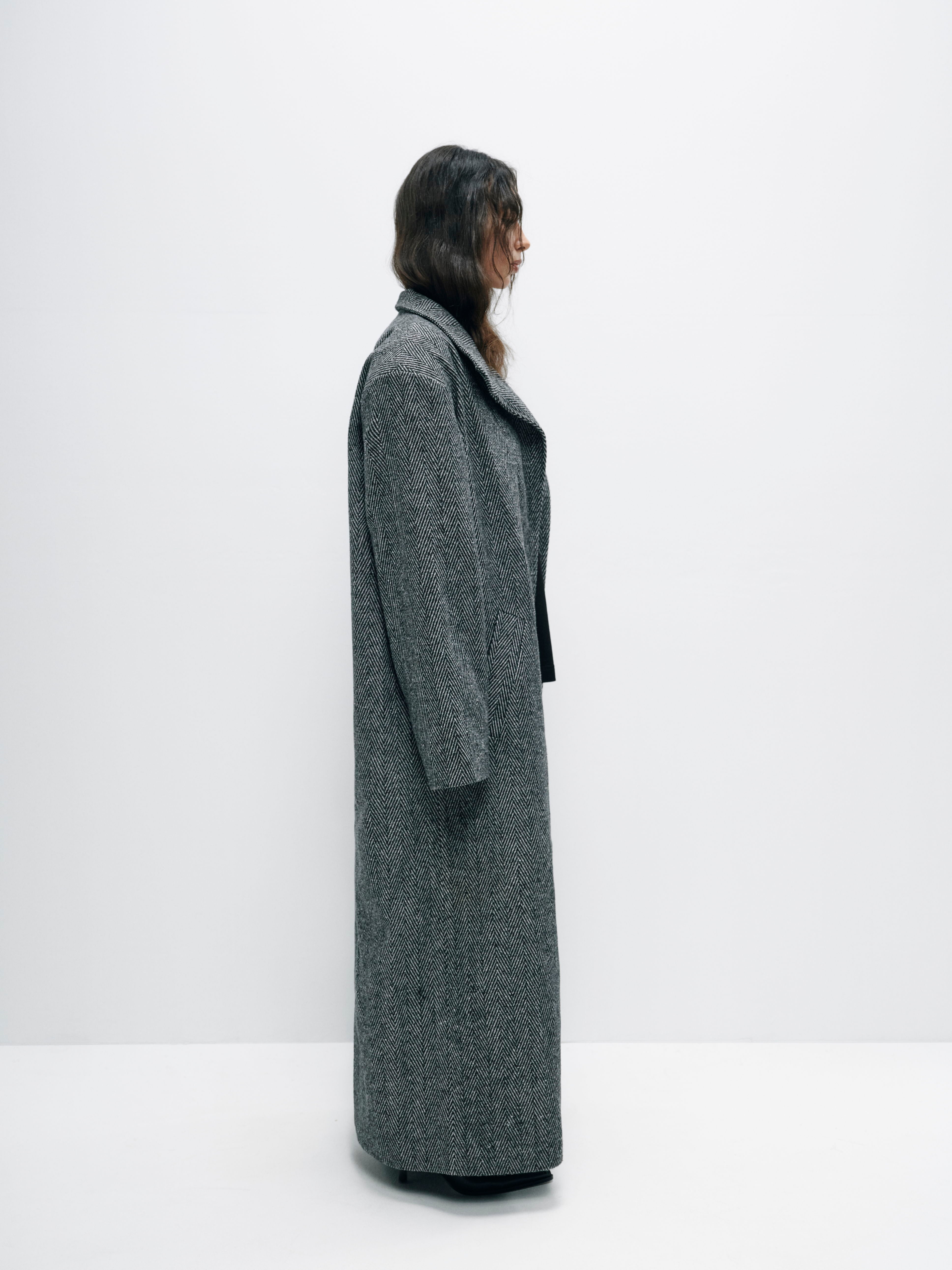 Side view of the coat, showcasing its sophisticated drape and balanced fabric weight