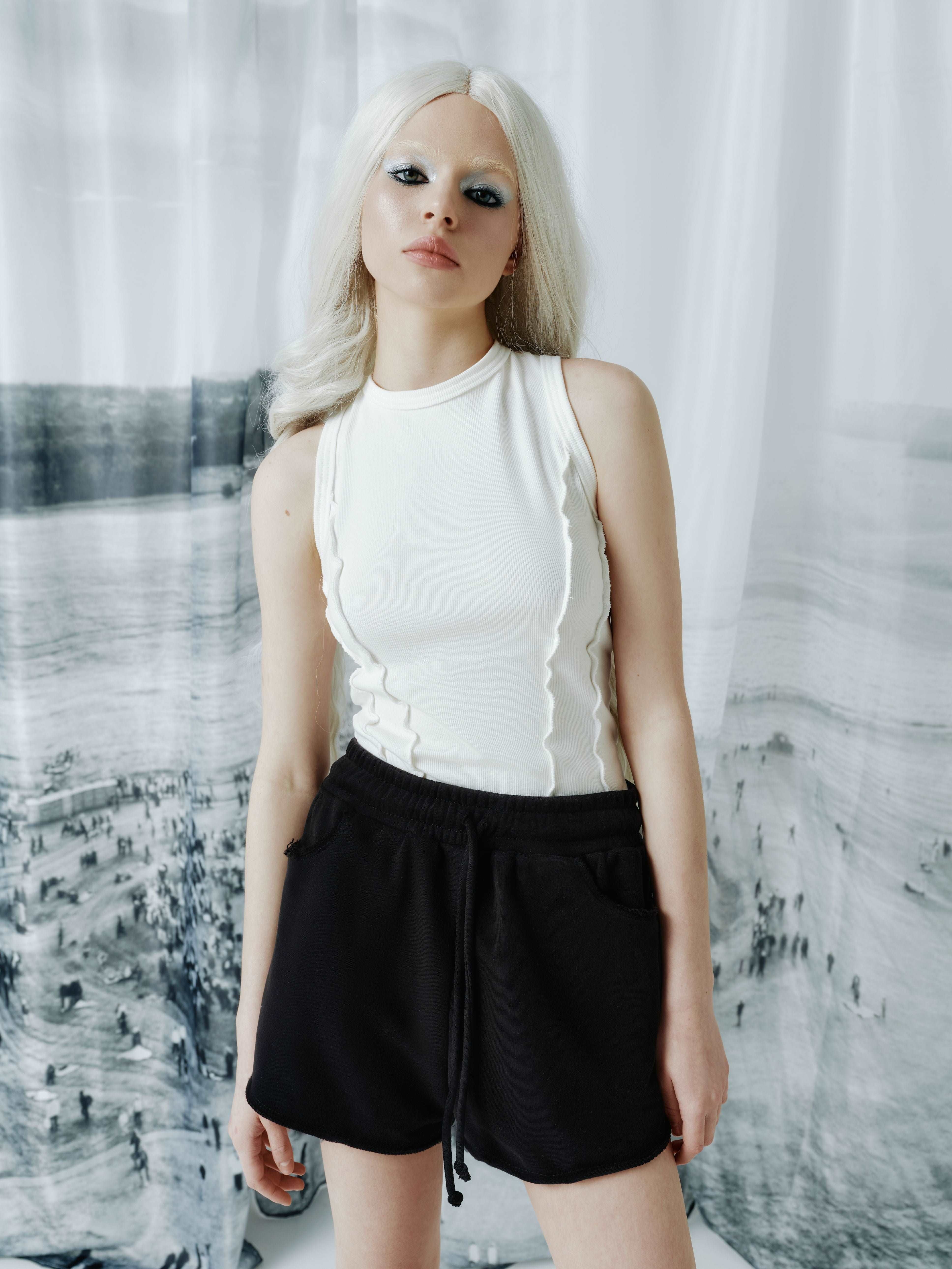Model wearing a ribbed tank top with corset-inspired front seams, highlighting its streetwear style and modern, edgy silhouette