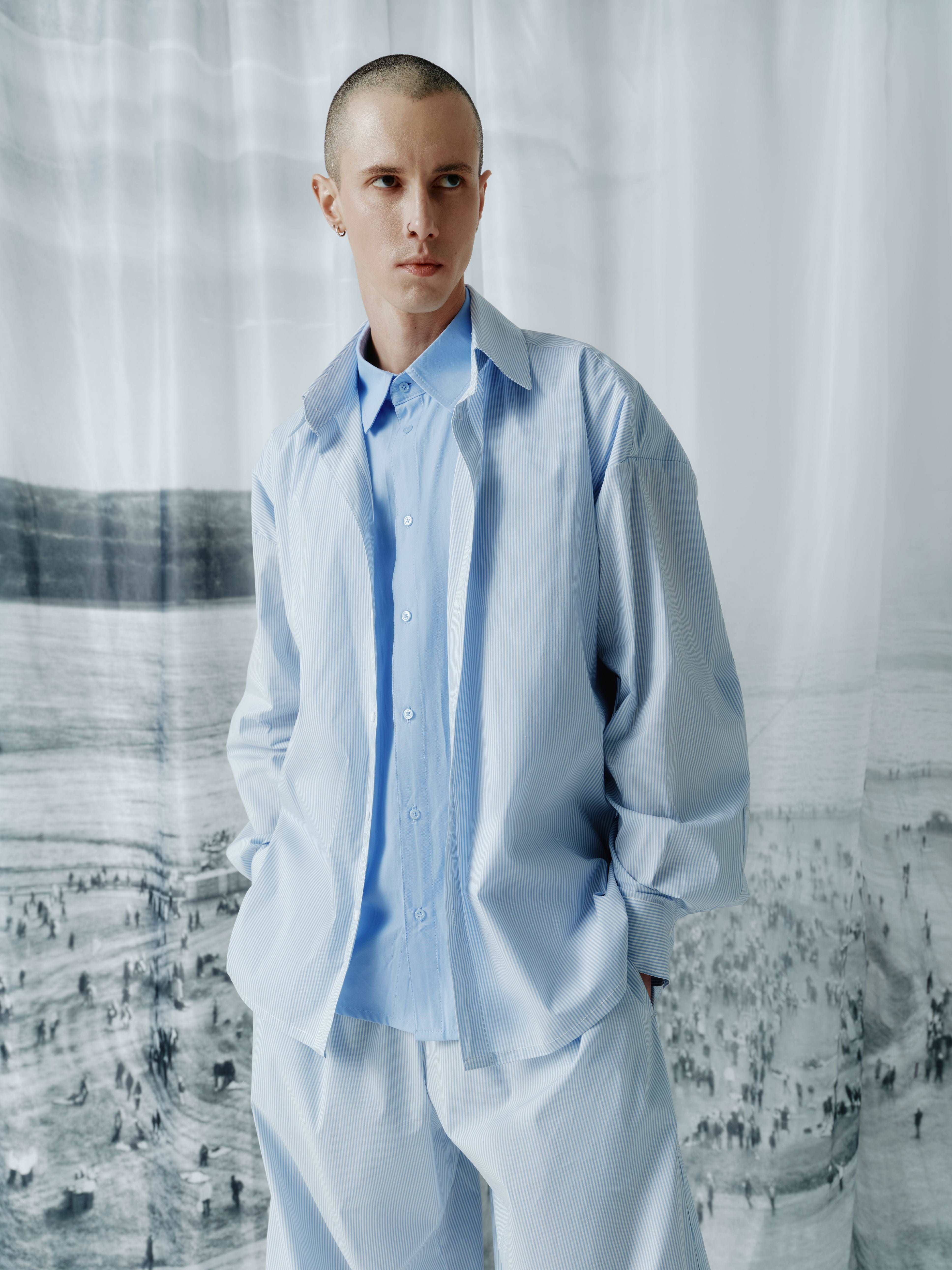 Full-length shot of the model wearing the double-layered, loose-fit shirt, showing the relaxed silhouette and stylish design