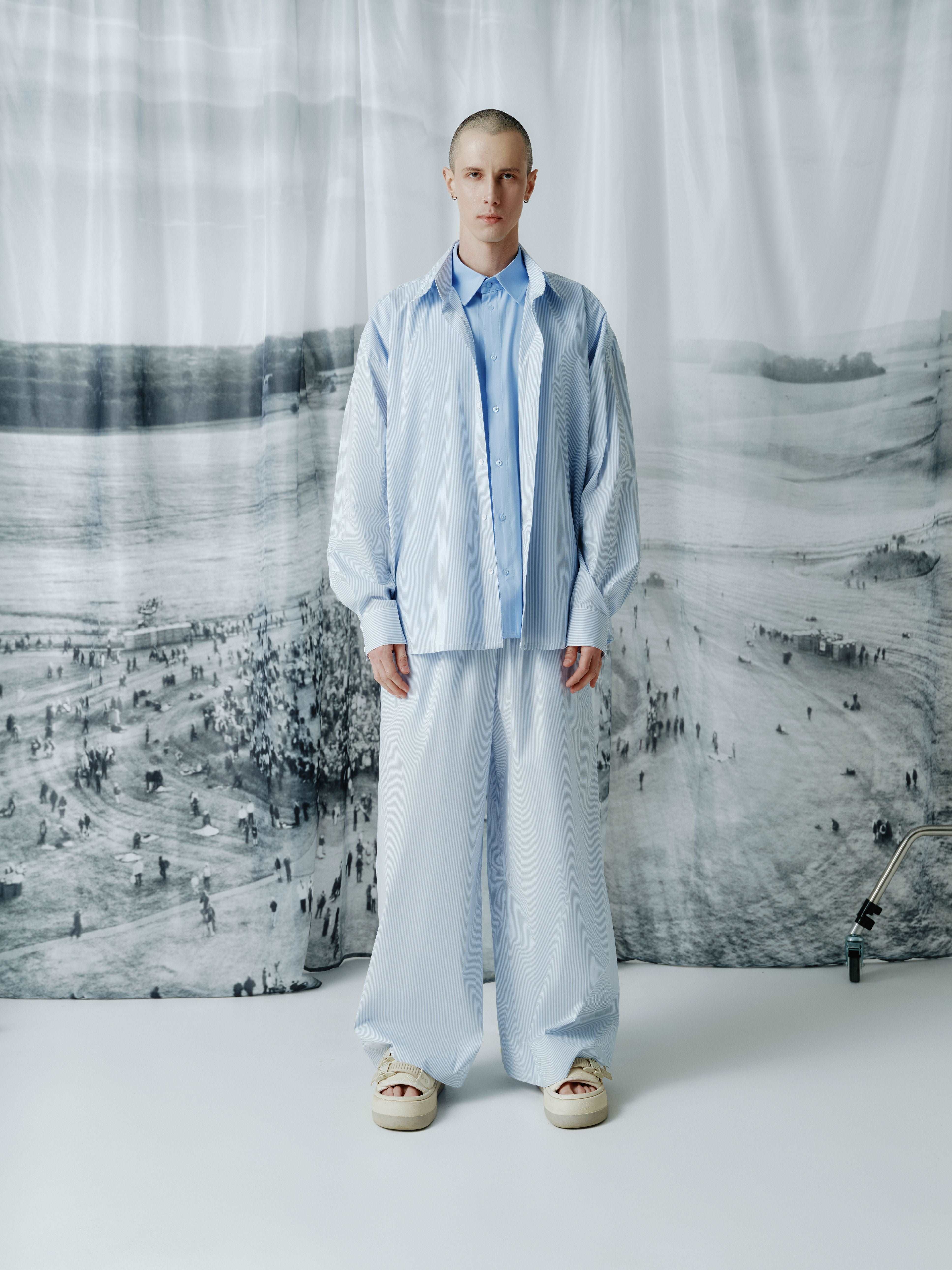 Model wearing full-length blue striped cotton wide-leg pants with a relaxed fit and an elastic waistband for a stylish and comfortable appearance