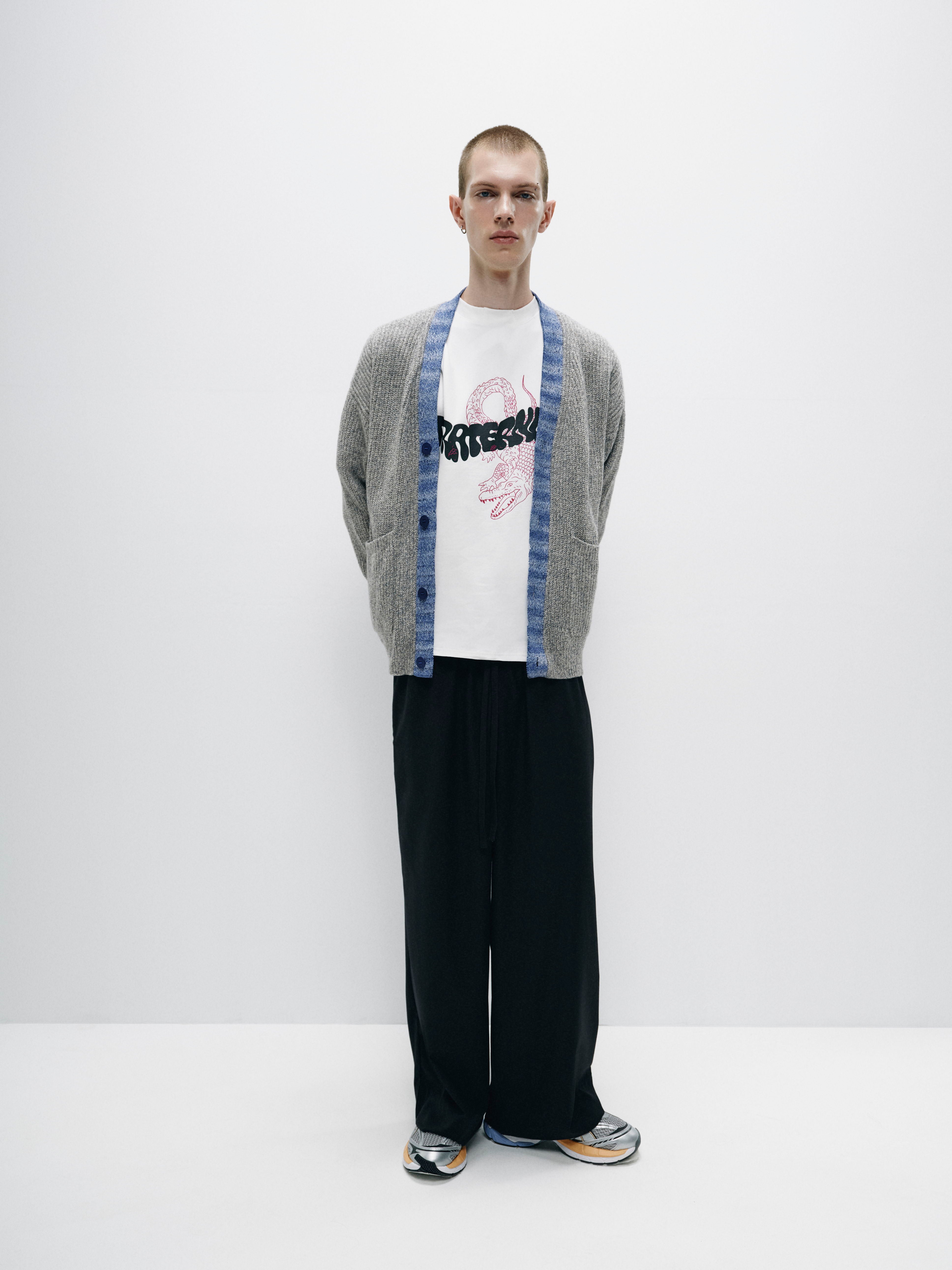 Model wearing full-length wide-leg pants made from suiting fabric, featuring an elastic waistband for a comfortable and secure fit, offering a modern, relaxed style