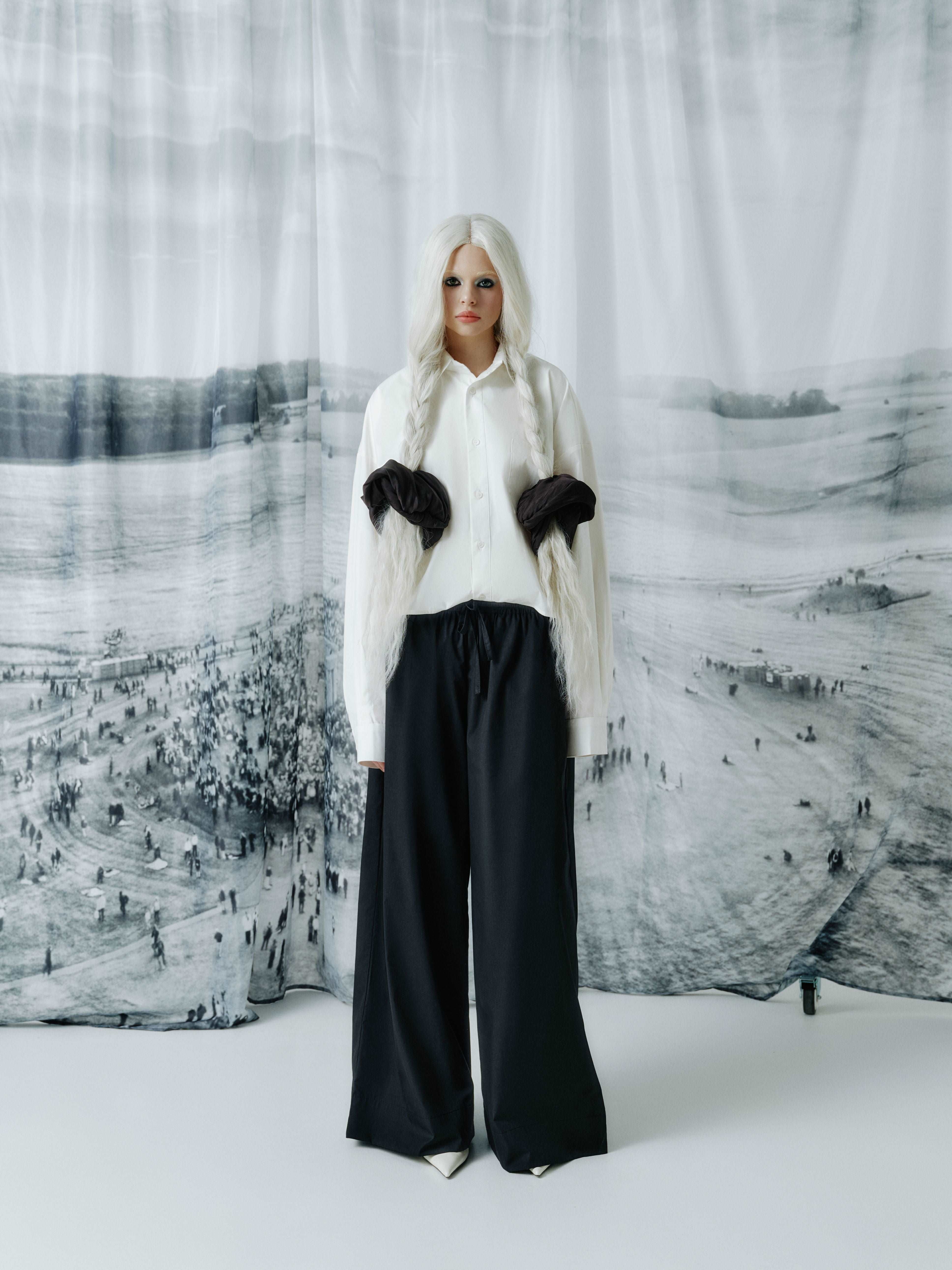 Model wearing full-length black cotton wide-leg pants with an elastic waistband, offering a modern, breezy silhouette and comfortable fit