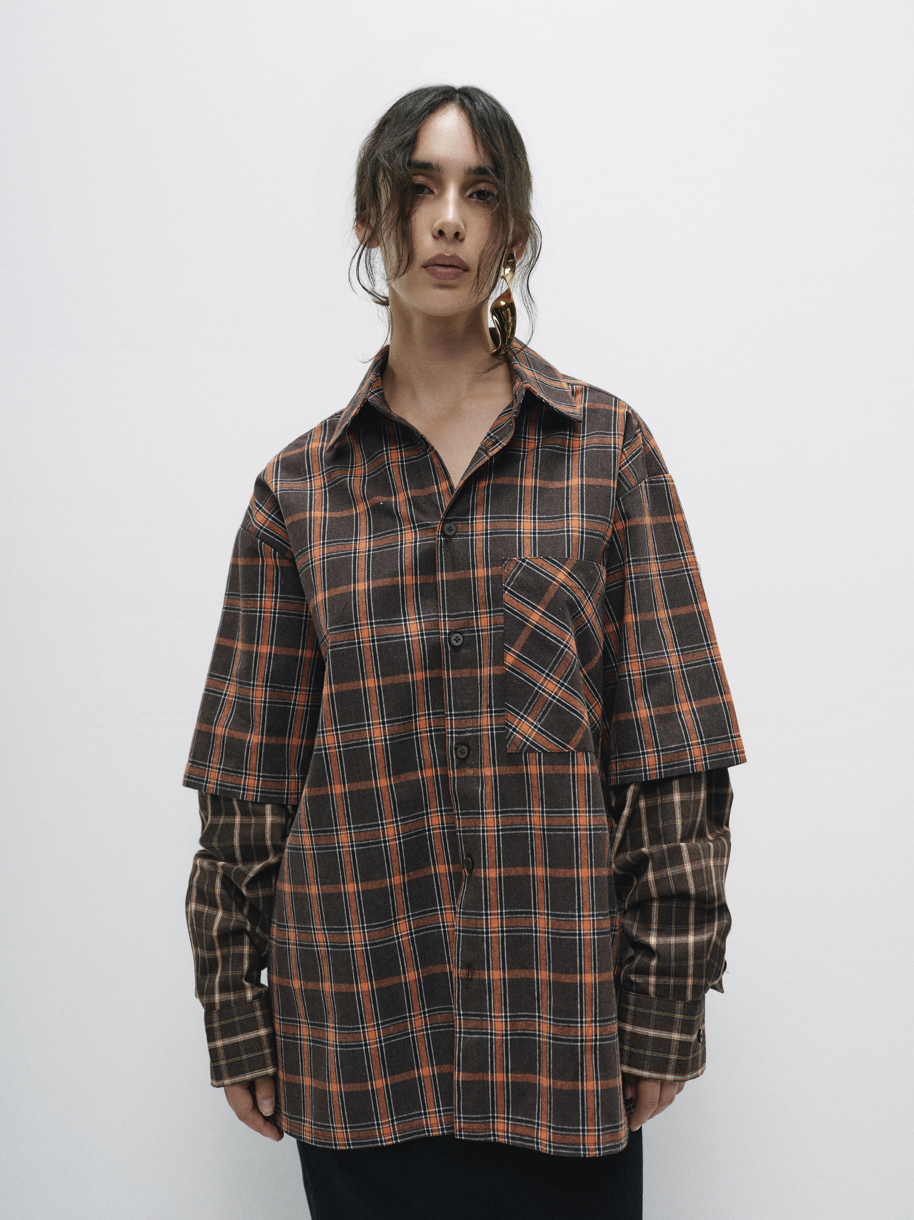 Model styling the oversized plaid shirt in a relaxed manner, showcasing its versatility as a layering piece