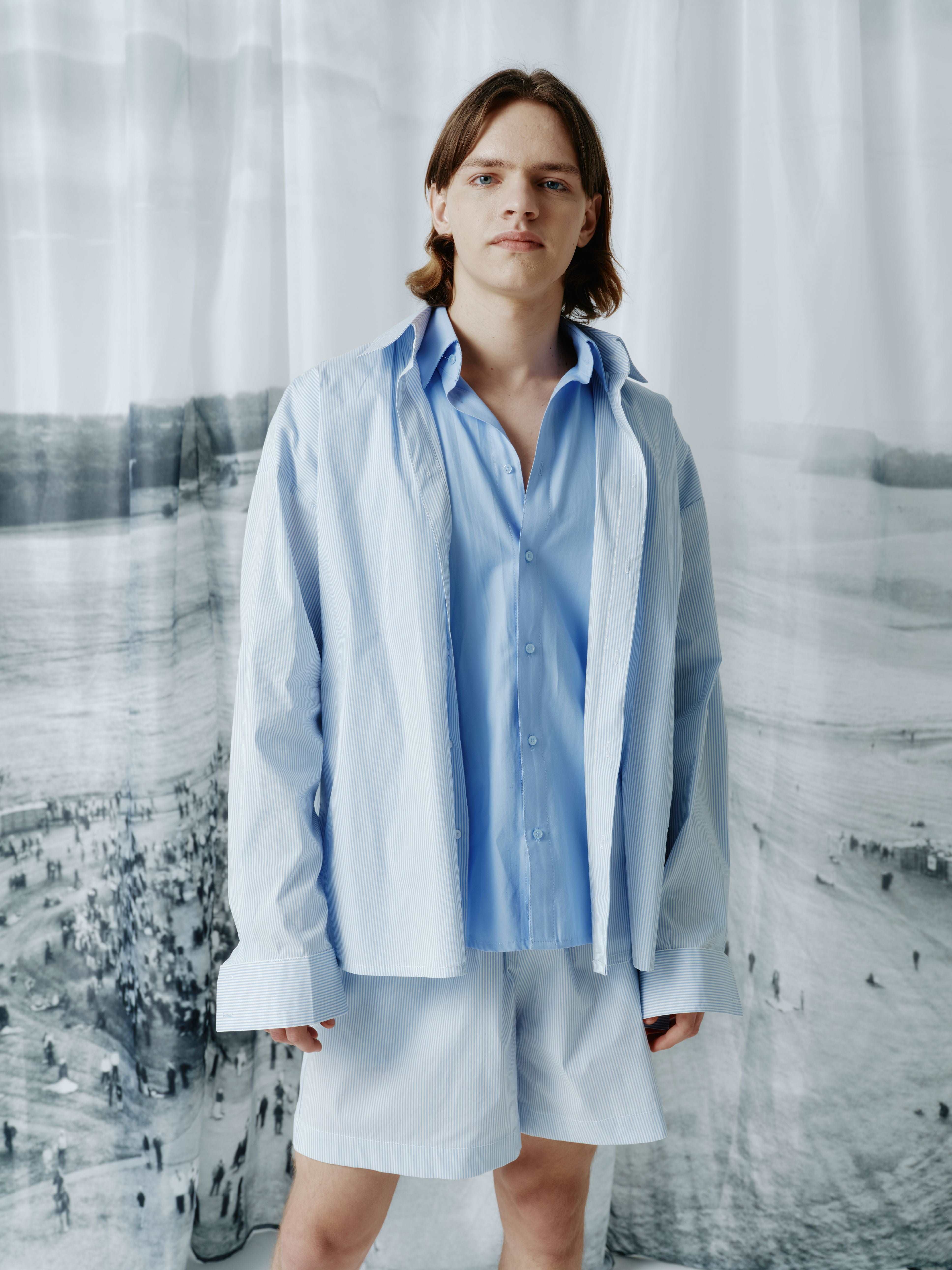 Model wearing a loose-fit shirt with double-layered fabric on the front, showcasing the effect of wearing two shirts in one