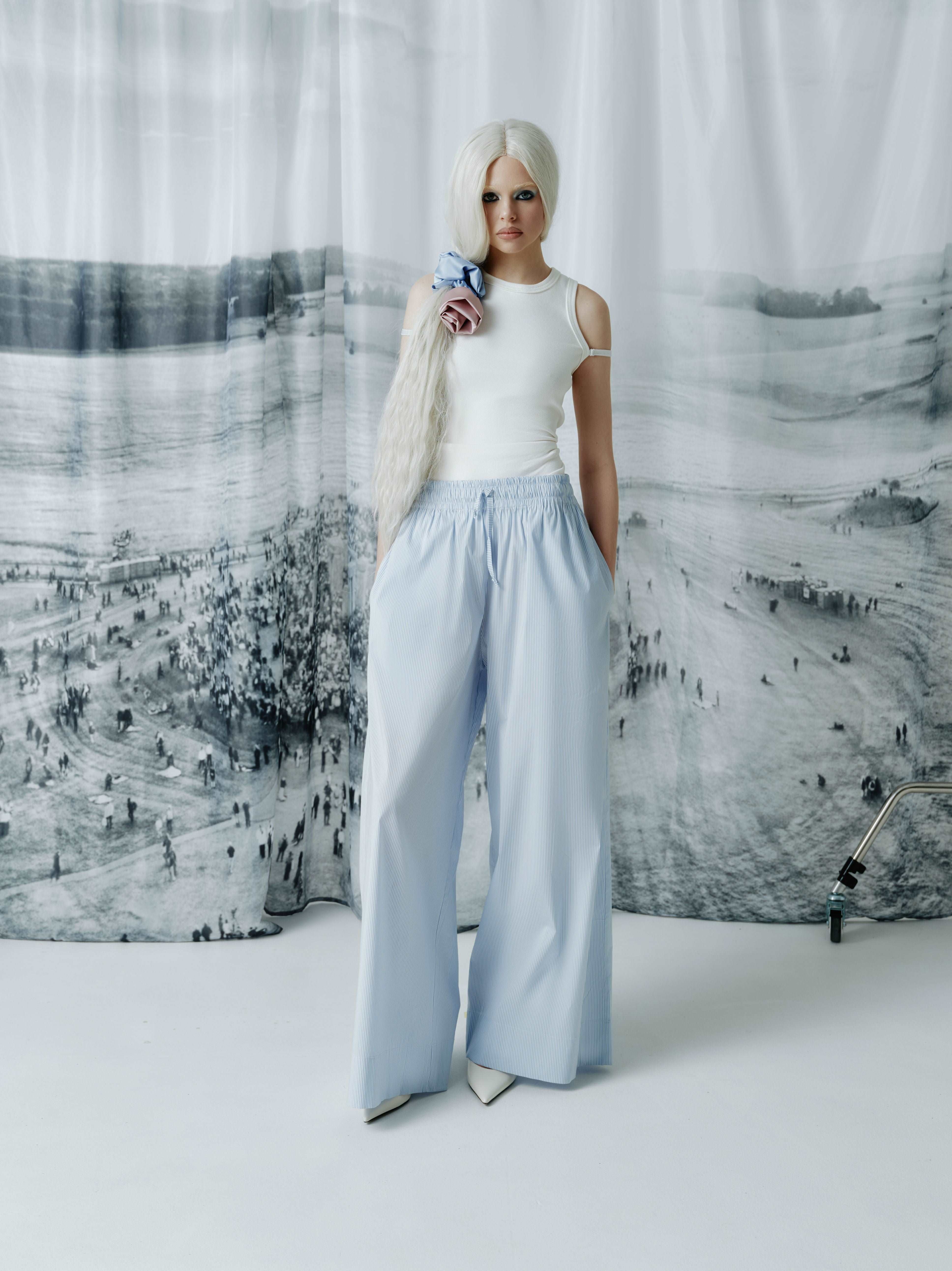 Model wearing full-length blue striped cotton wide-leg pants with a modern elastic waistband, offering a stylish and comfortable fit