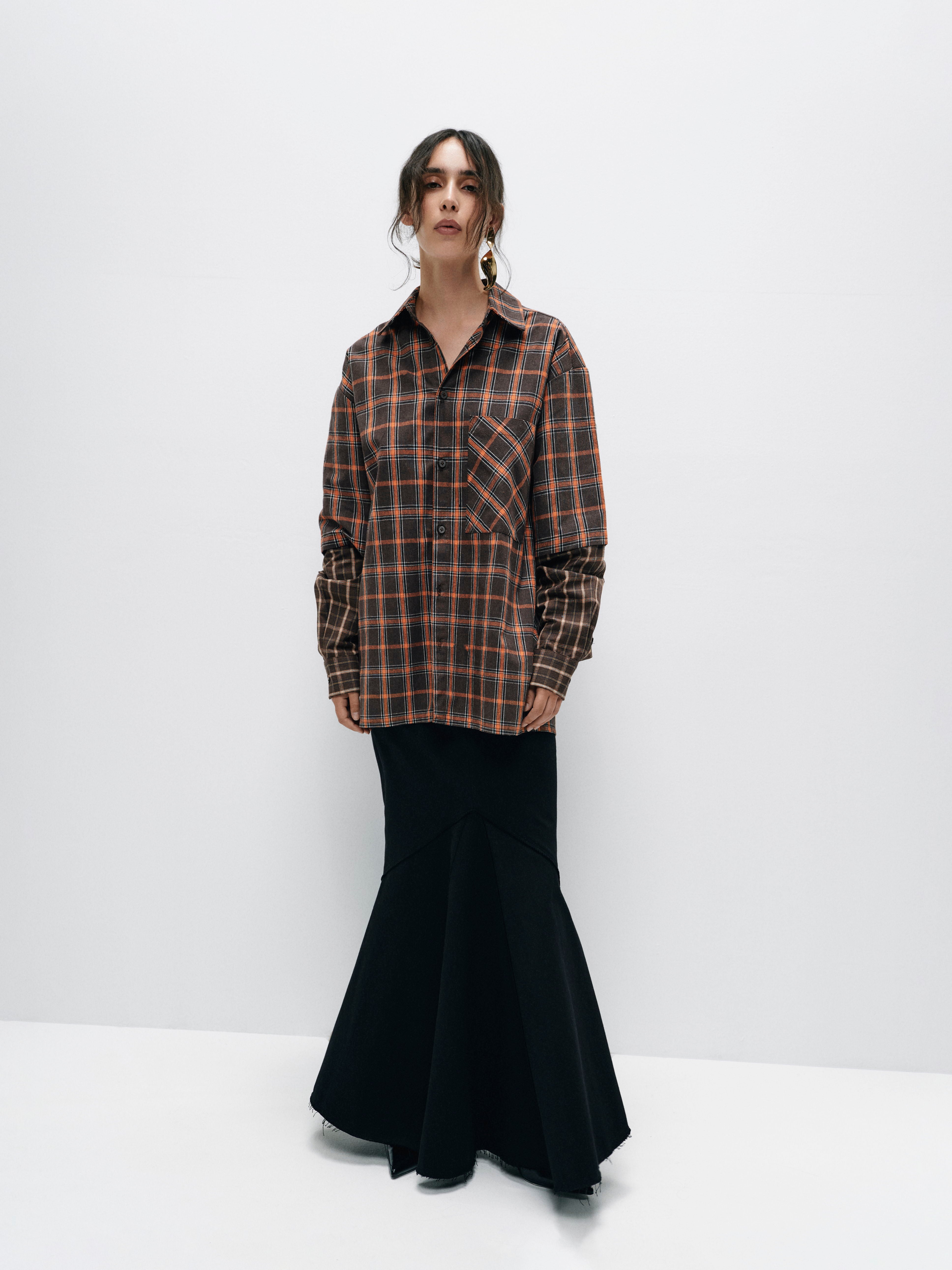 Model wearing an oversized cotton plaid shirt with contrasting sleeves, showcasing a relaxed, comfortable fit and modern design