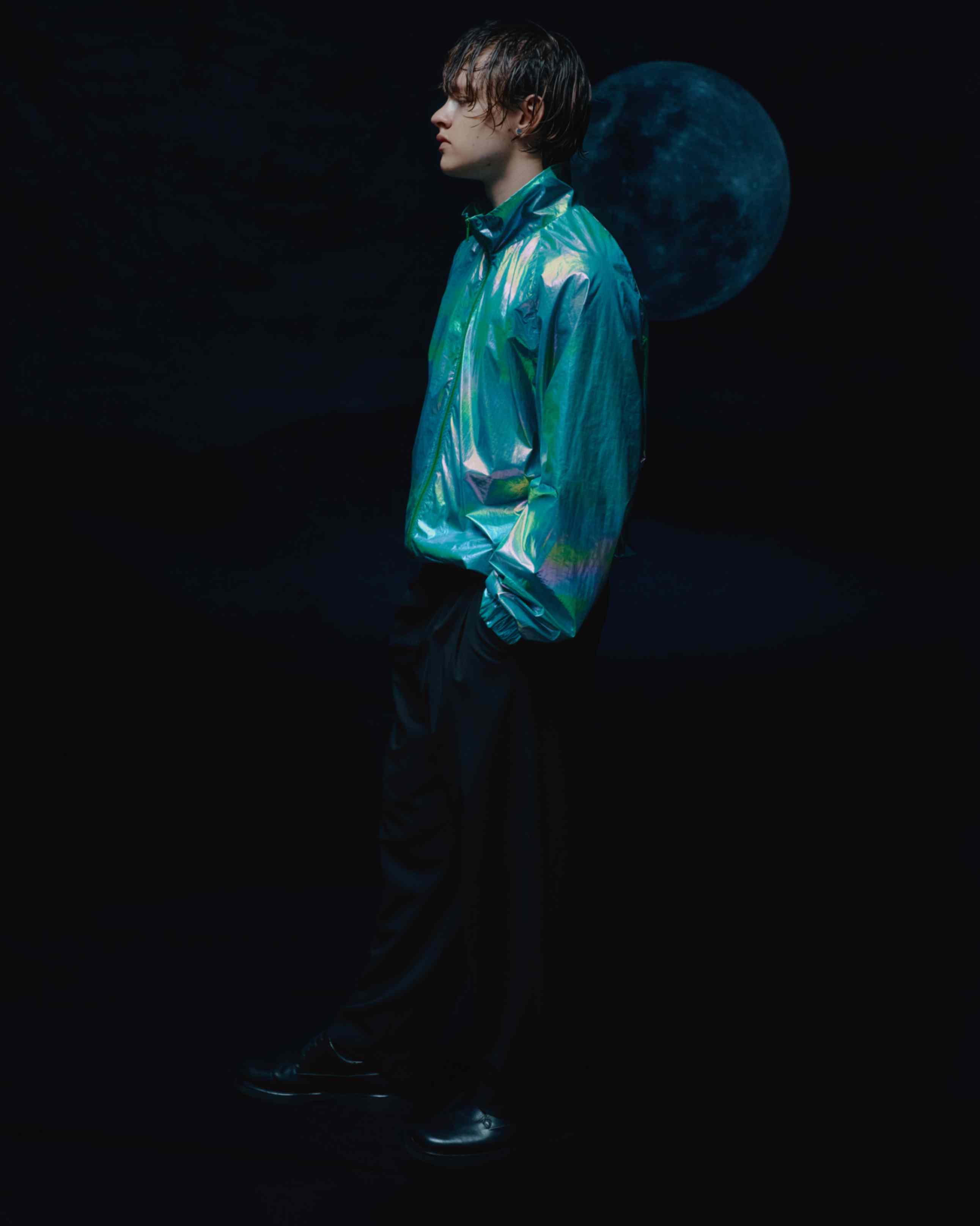 Side view of the model in oversized holographic windbreaker, highlighting the relaxed, unisex fit and dynamic visual impact