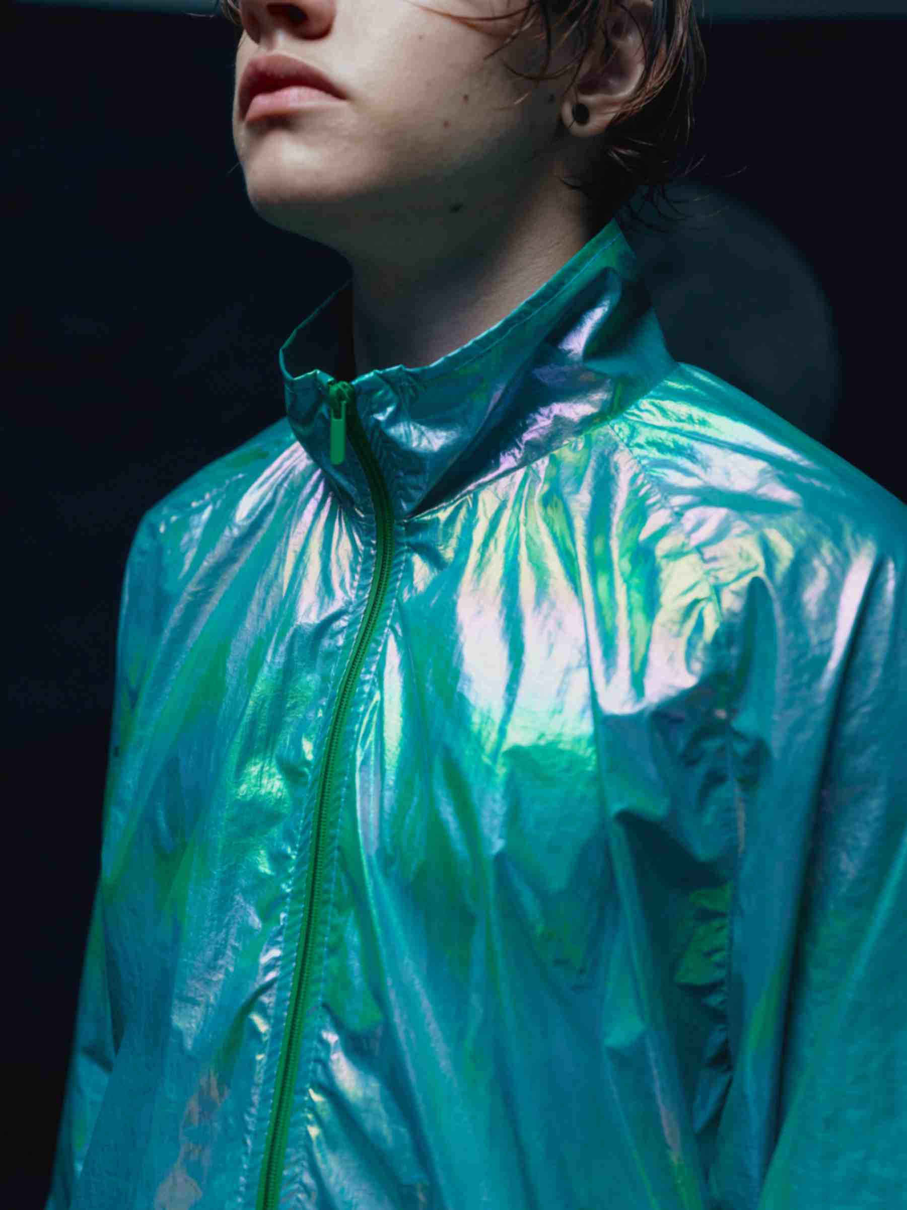 Back view of the model wearing holographic windbreaker, showing the oversized design and the stunning, light-reflective fabric