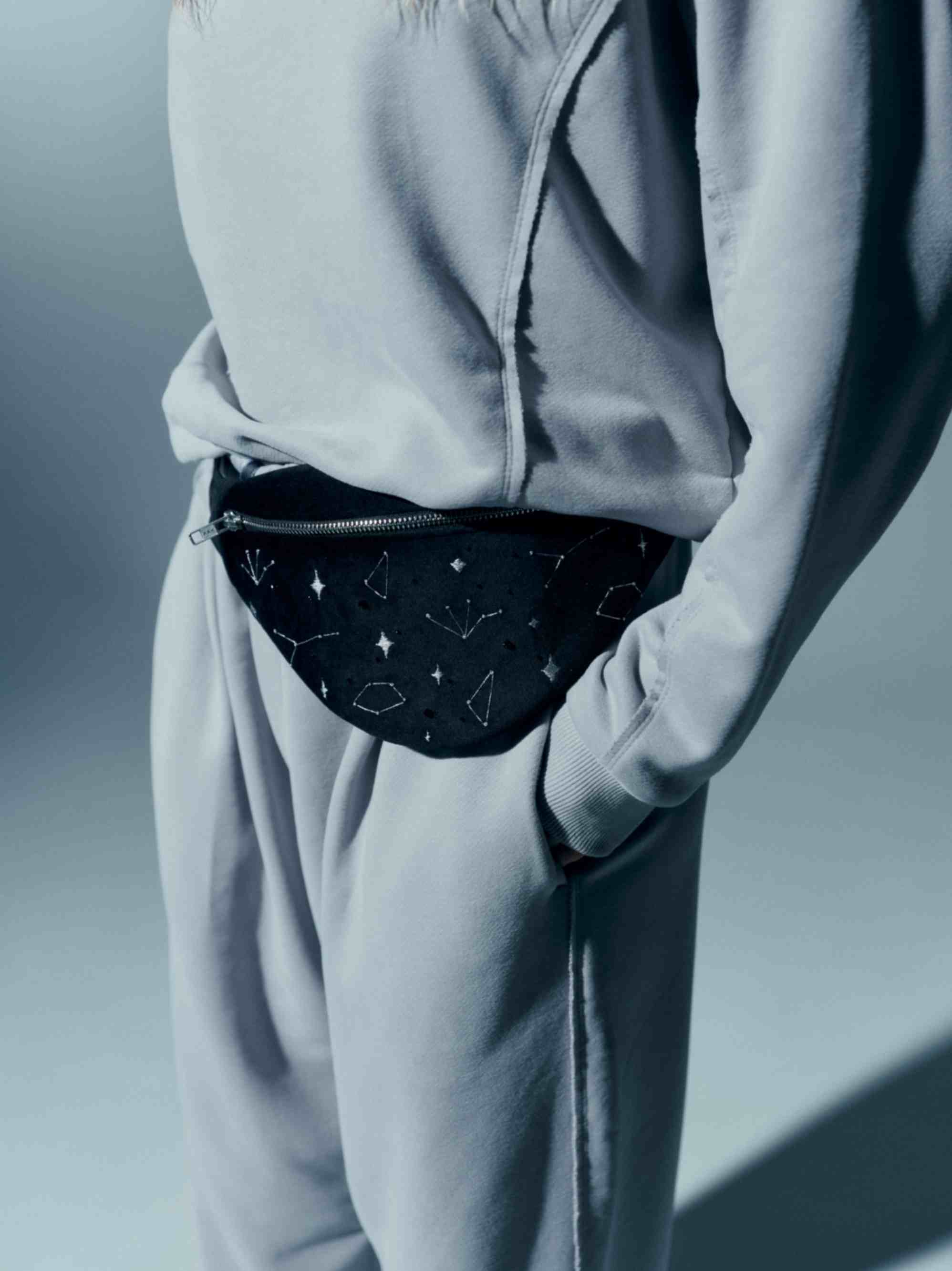 Model displaying the velvet waist bag from the side, showcasing its elegant and eye-catching design with embroidered details
