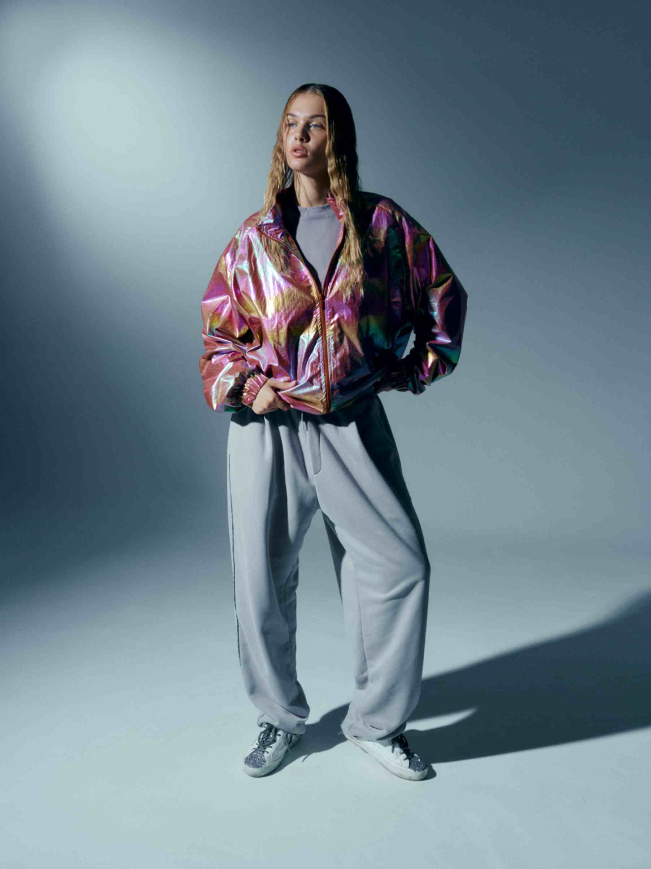 Close-up view of the holographic finish on the oversized windbreaker, emphasizing the shimmering, light-reflecting surface