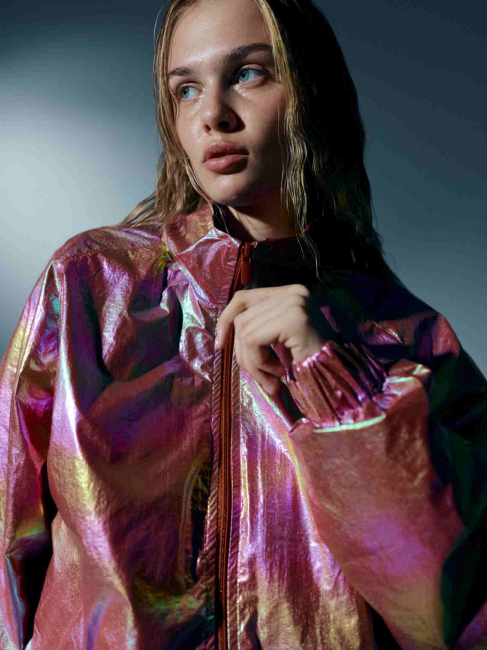 Close-up of the windbreaker’s details, focusing on the zipper and pockets, with the holographic material catching the light