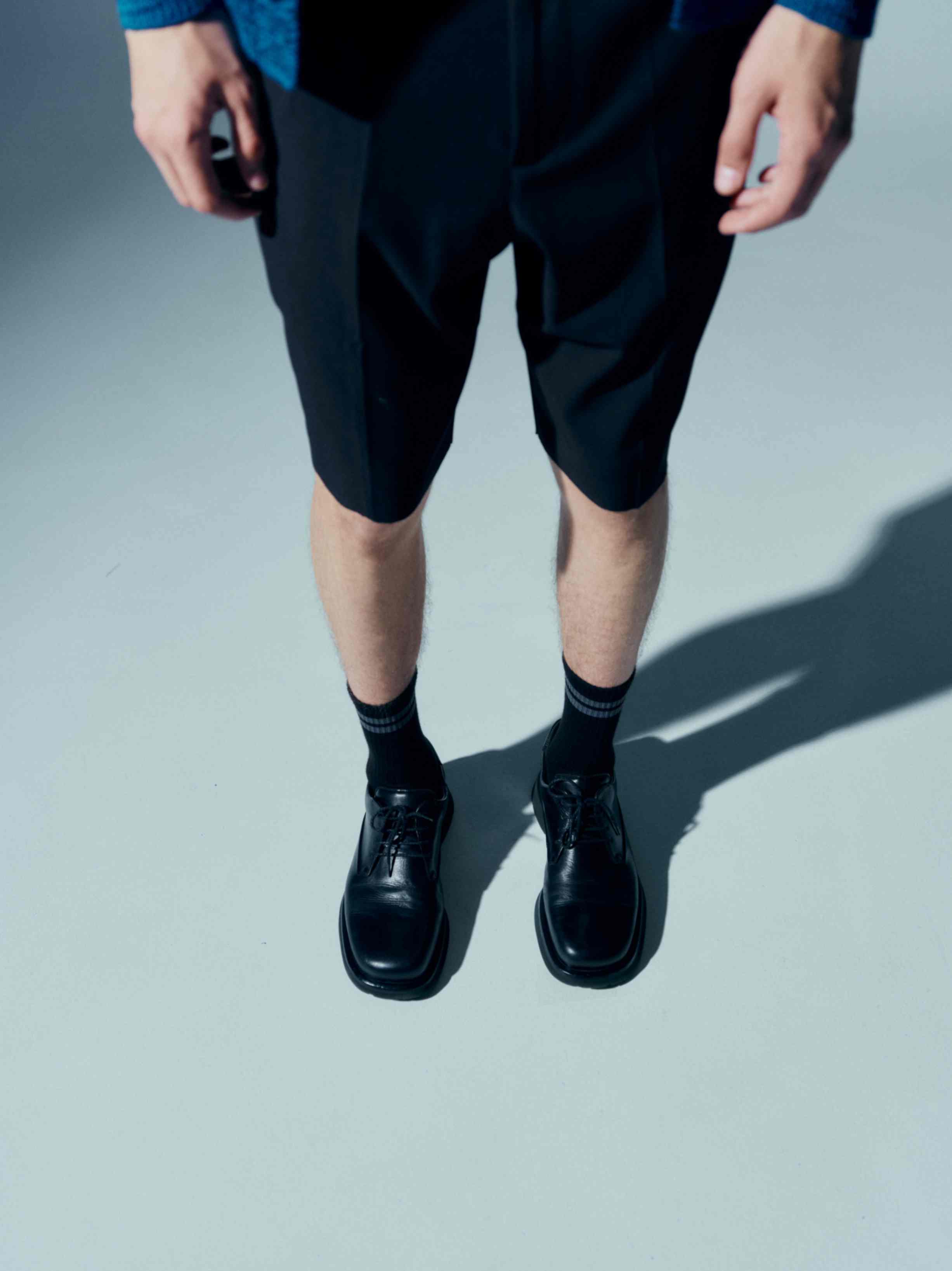 Model wearing the cotton socks with dress shoes, showing how the stylish stripes and logo elevate the look for more dressed-up occasions
